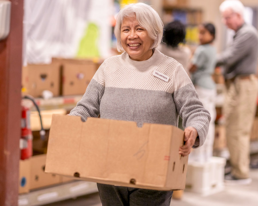 happy volunteer carrying a box